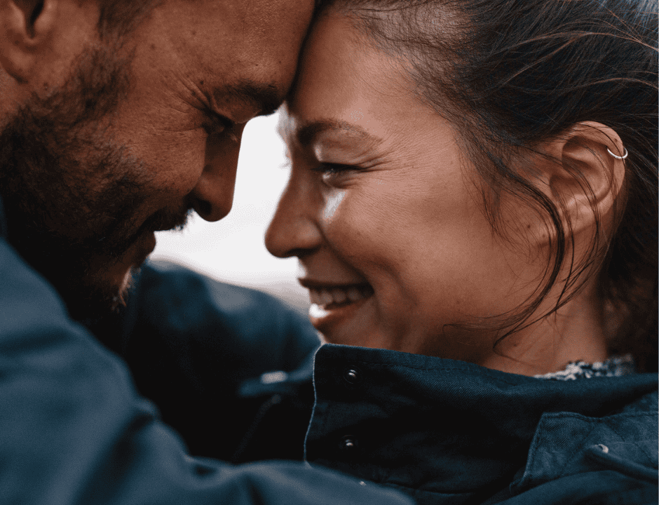 Couple hugging and smiling at each other.