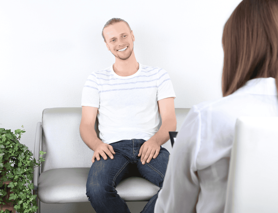 Man smiling while speaking to a counsellor
